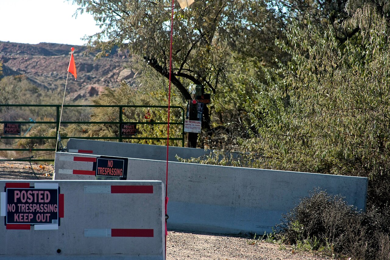 The gated entrance to Skinwalker Ranch, blocked by concrete barriers and no-trespassing signs.